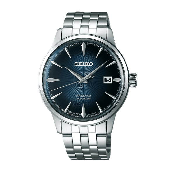 Sølvfarget Seiko Presage-klokke med blå teksturert urskive, sølvfargede timemarkører og datovindu klokken 3 på en metalllenke.