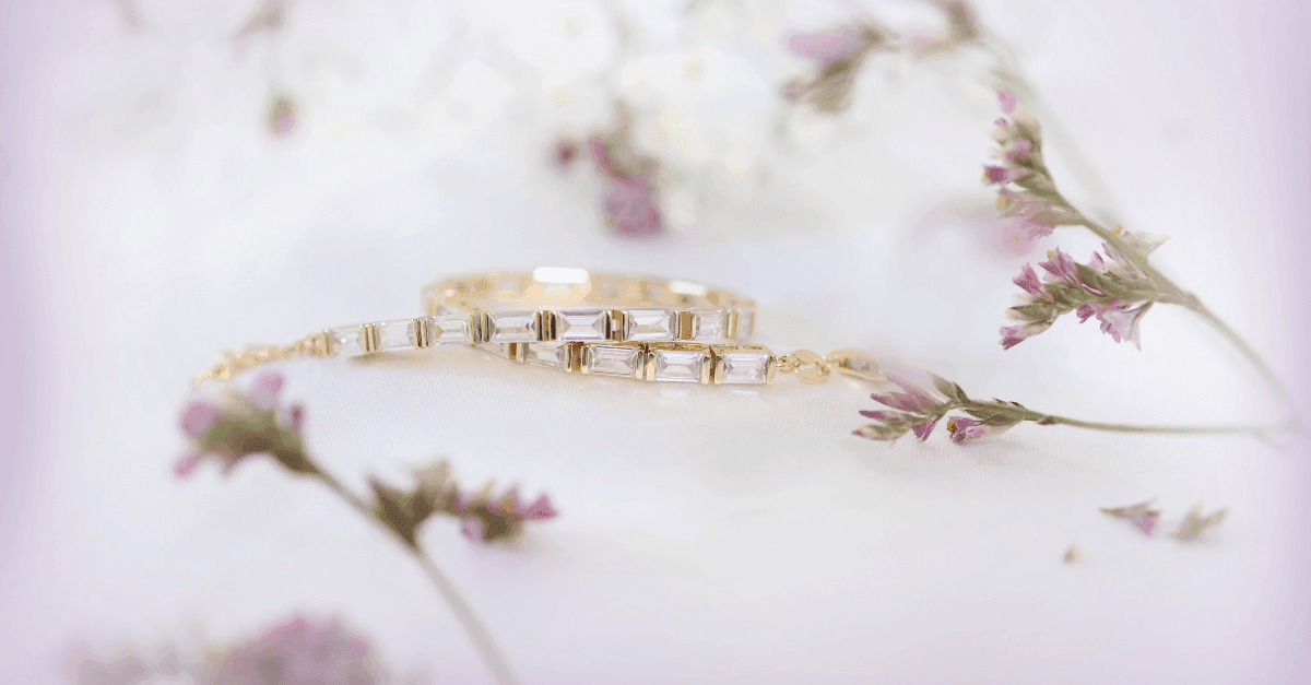 Nærbilde av et armbånd med blanke stener som ligger omringet av blomster