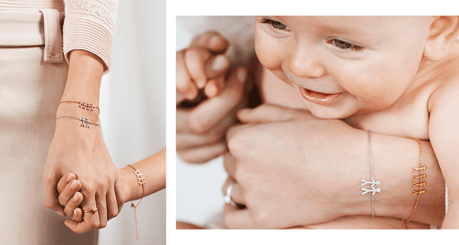 Et nærbilde av en kvinne og en baby som holder hender, iført matchende gull- og sølvarmbånd med små sjarm-figurer.