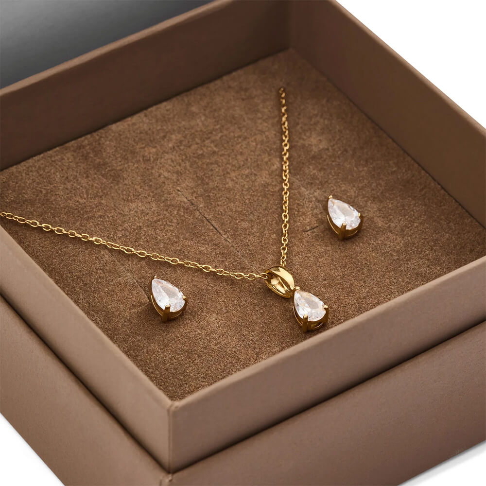 Gavesett med gullfarget smykke og matchende dråpeformede øredobber plassert i en brun eske med formskåret innmat.