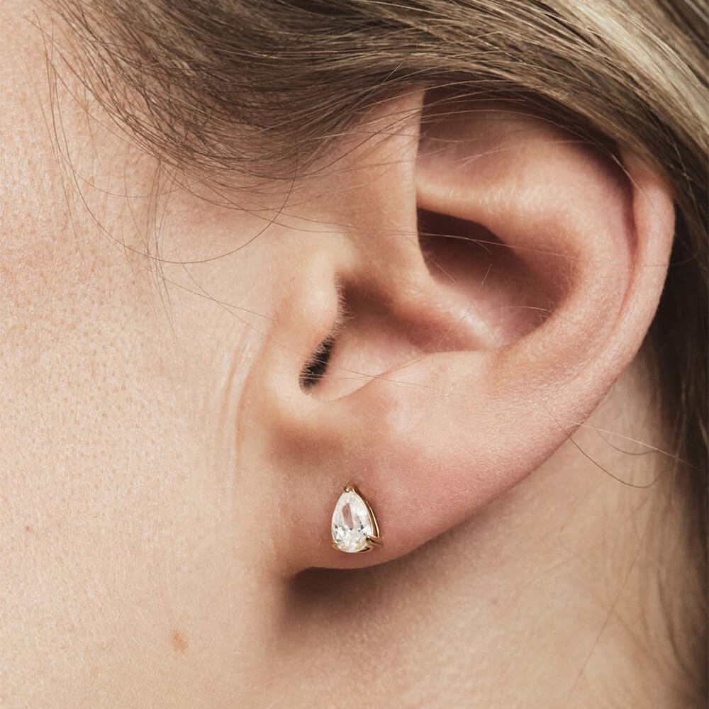 Gavesett med gullfarget smykke og matchende dråpeformede øredobber plassert i en brun eske med formskåret innmat.