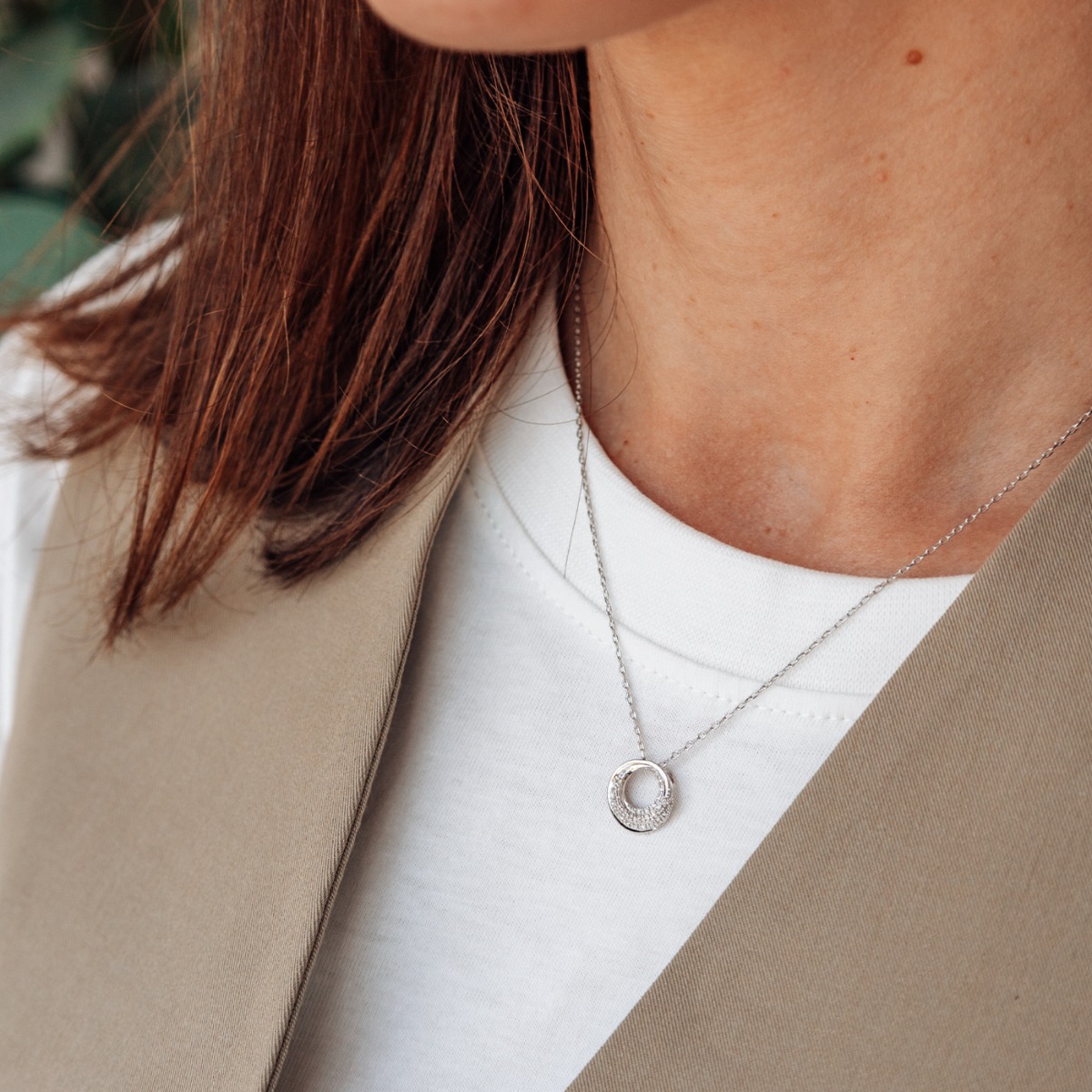 Diamantsmykke i hvitt gull med rund sirkelanheng og pavéfattet design, vist mot hvit bakgrunn.