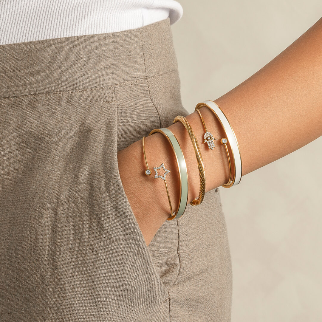 Armring i åpen design med glatt, hvit midtstripe og gullfargede kanter, vist mot hvit bakgrunn med skyggeeffekt