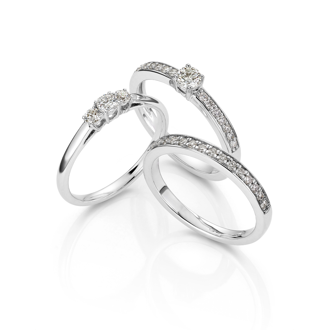 Elegant ring i hvitt gull med en rekke små, glitrende diamanter felt ned i en smal skinne rundt toppen av ringen.