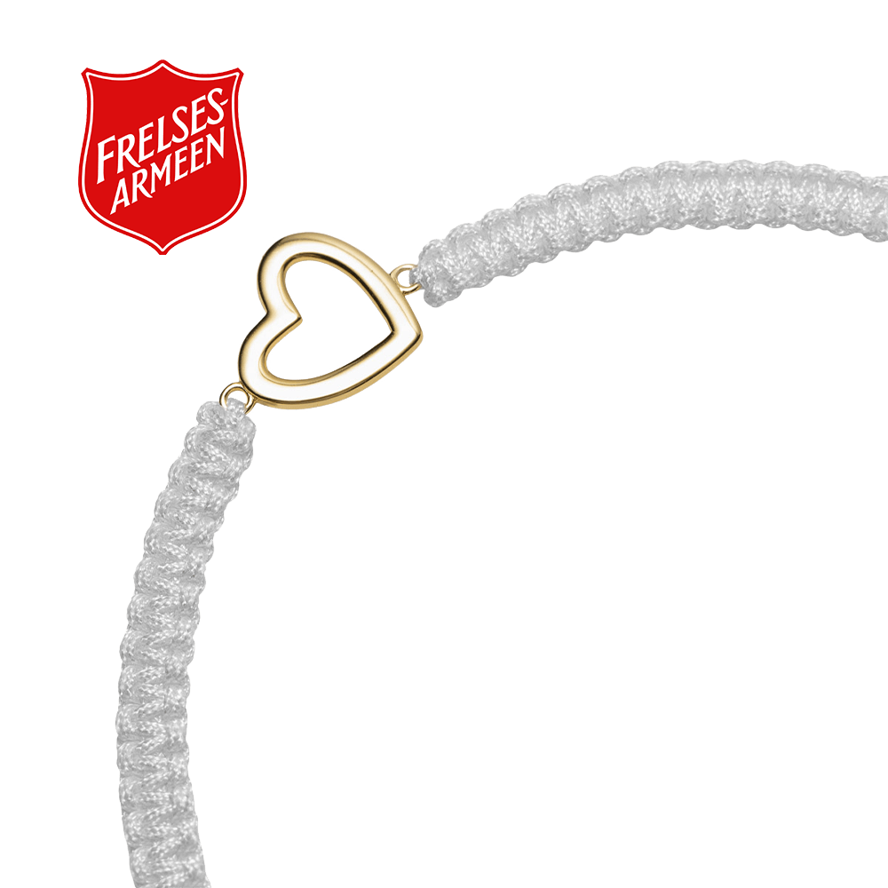 Et Frelsesarmeen vennskapsarmbånd i hvitt med smykke i forgylt sølv på hvit bakgrunn og rød Frelsesarme-logo øverst til venstre.