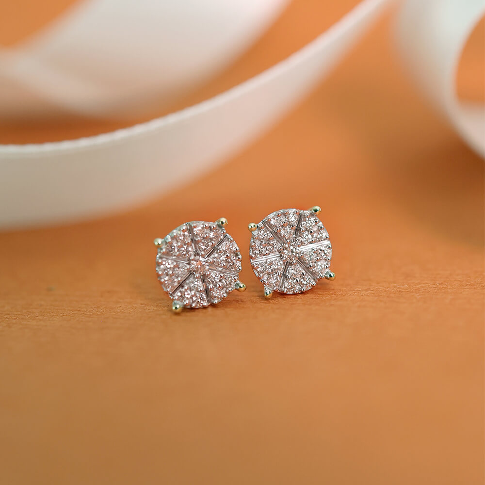 Et par øredobber i gult metall med runde diamantklynger i stjerneformet innfatning, vist mot hvit bakgrunn.