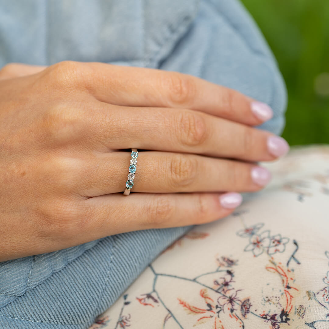 Vakker ring i hvitt gull med glitrende blå og hvite stener.