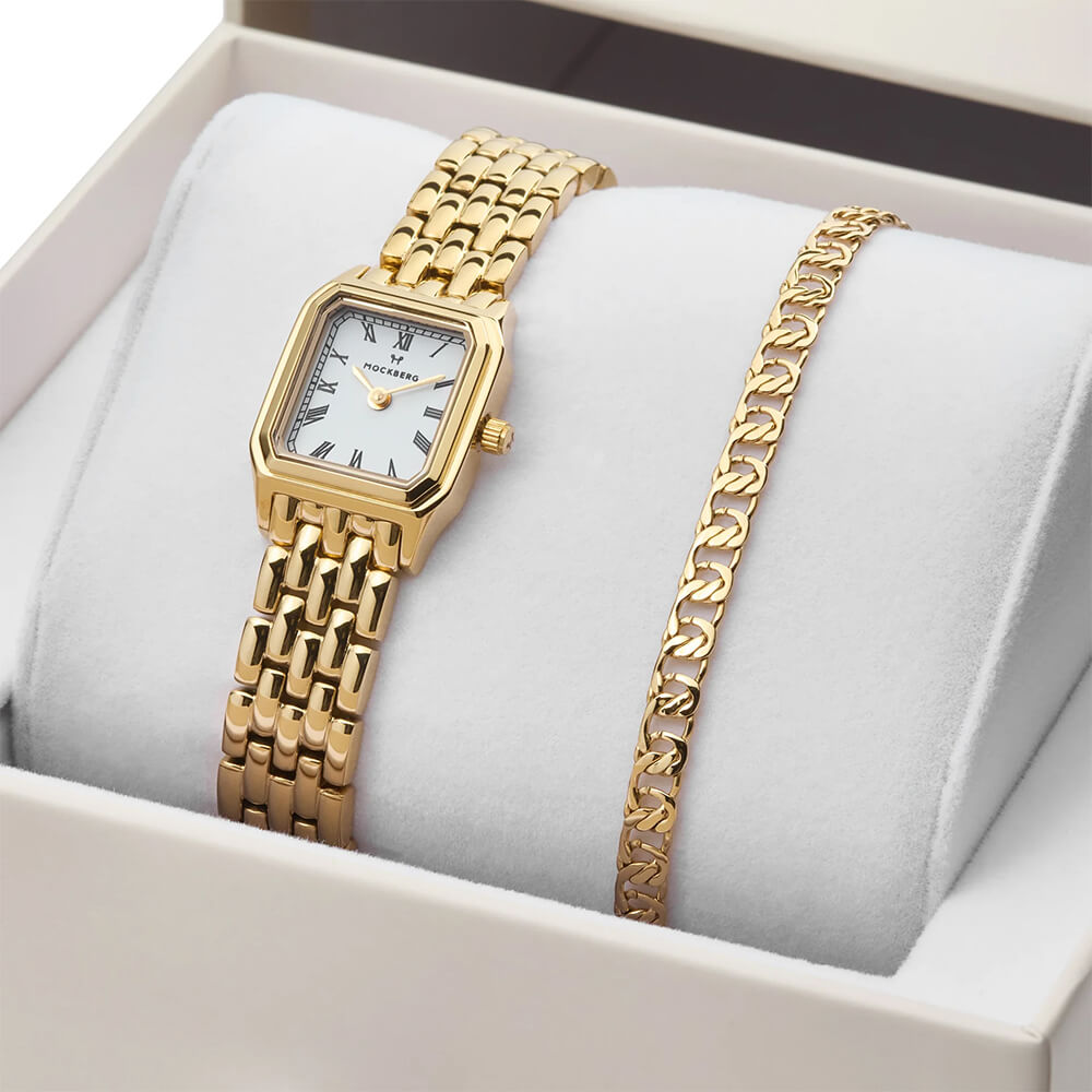 Gullfarget armbåndsur med hvit urskive og matchende lenkearmbånd presentert i lys gaveeske med Mockberg-logo