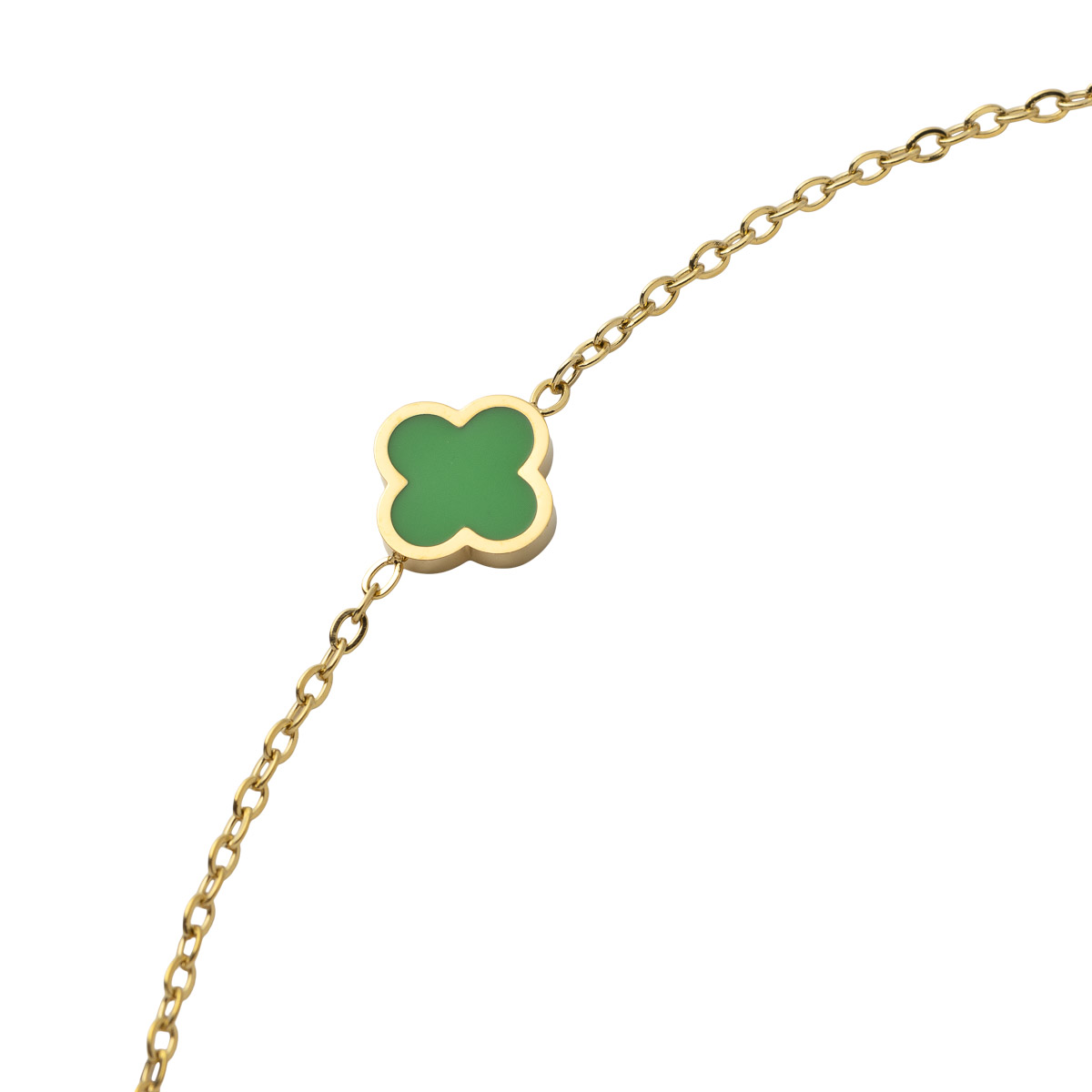 Gullfarget kjedearmbånd med lite grønt firkløverformet anheng i midten, fotografert mot hvit bakgrunn.