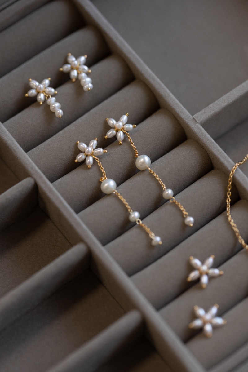 Øredobber i gullfarge formet som blomster med lange hengende 3 perler.