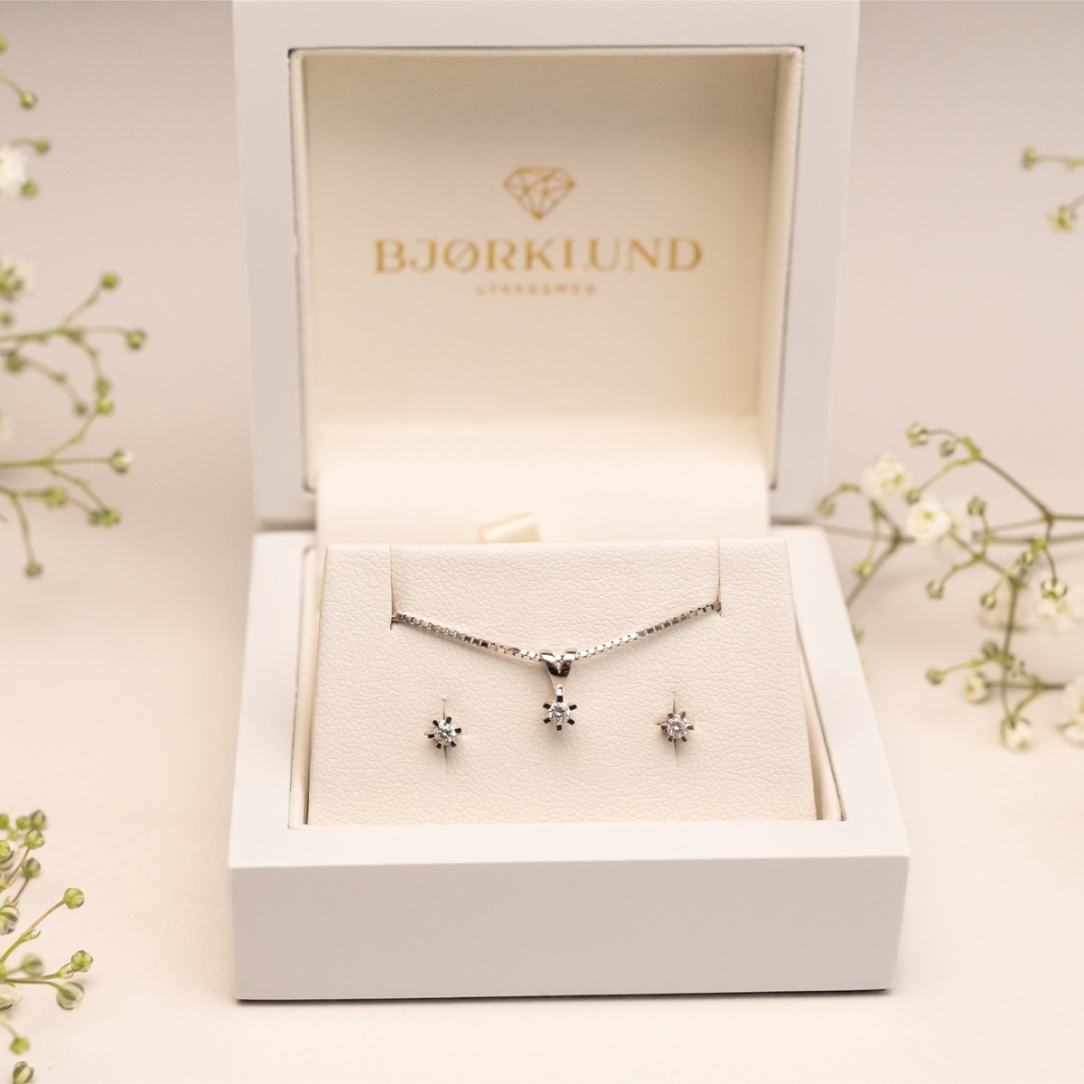 Et par øredobber med klare steiner festet i sekskantede innfatninger, laget i lyst metall og avbildet på hvit bakgrunn.