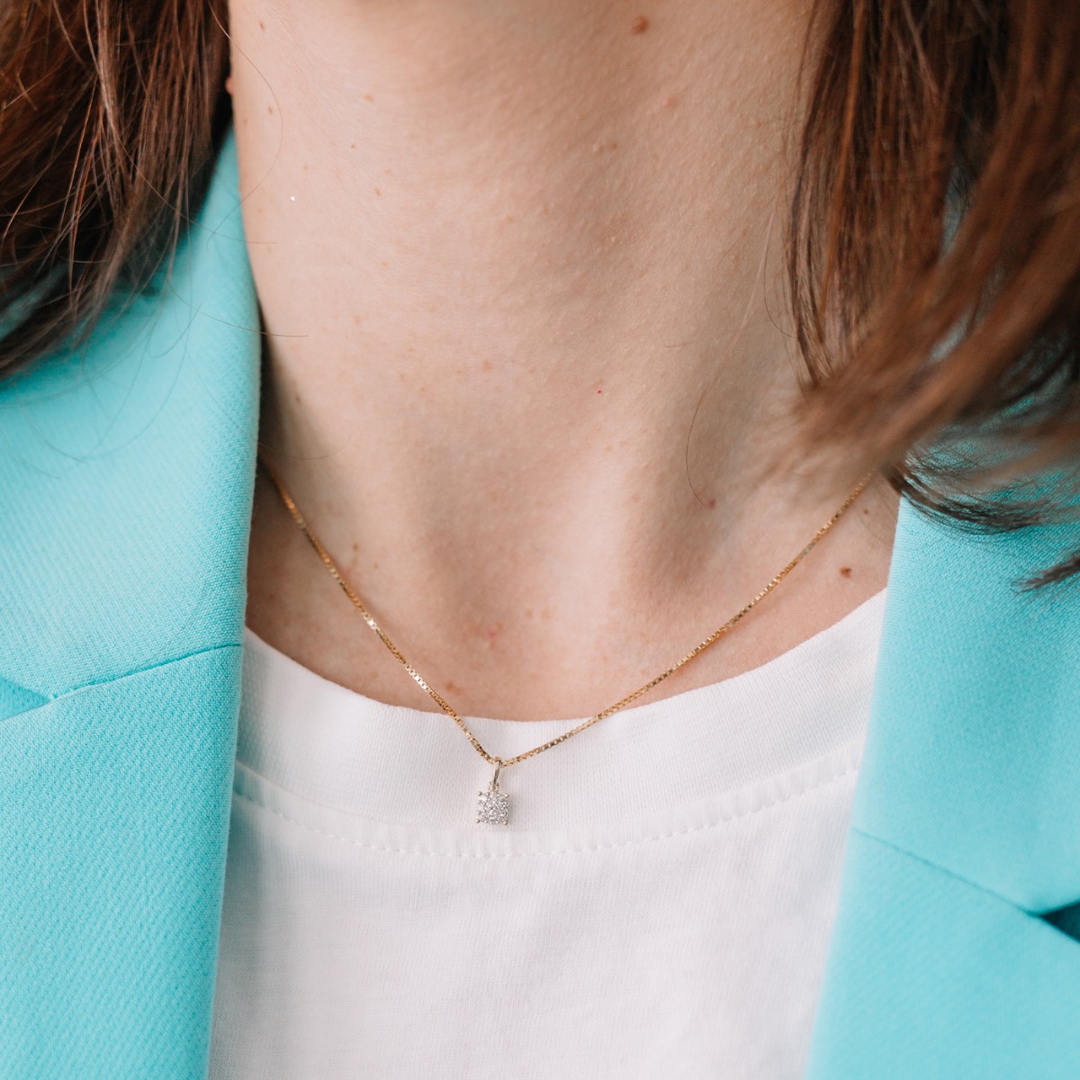 Halssmykke i gult gull med rund anheng i klofatning, dekorert med små glitrende diamanter.