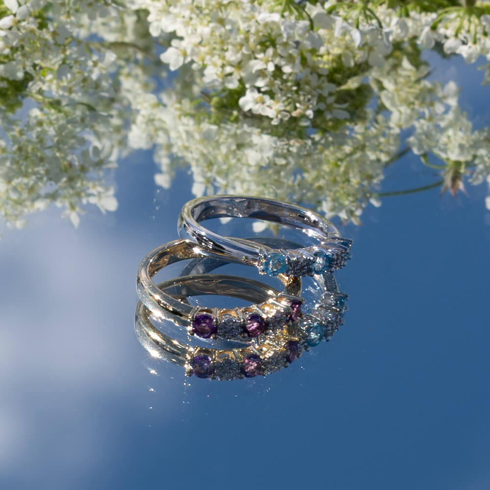 Vakker ring i hvitt gull med glitrende blå og hvite stener.