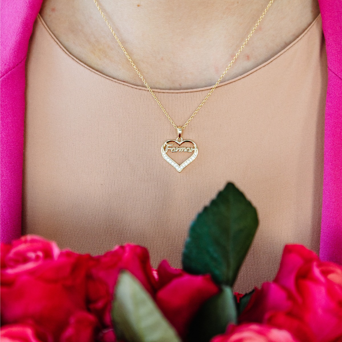 Gullkjede med hjerteformet anheng dekorert med glitrende steiner og teksten «Bestemor», presentert på hvit bakgrunn.