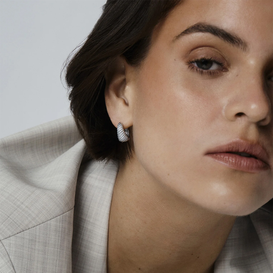 Et par øreringer med lekre detaljer som likner på prikker i sølvfarget stål.