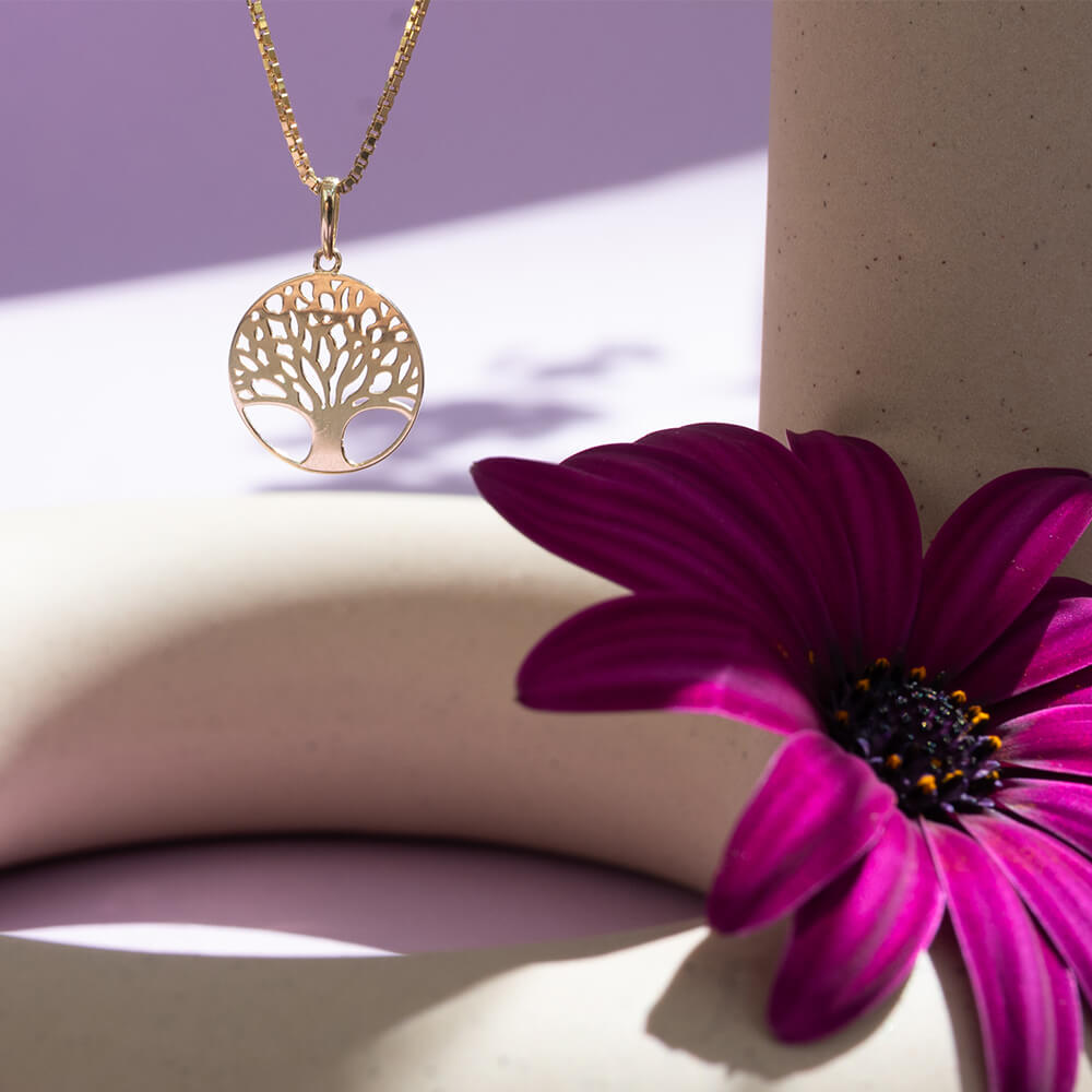 Halssmykke i gult gull med rundt anheng formet som Livets tre i et åpent og symmetrisk design.