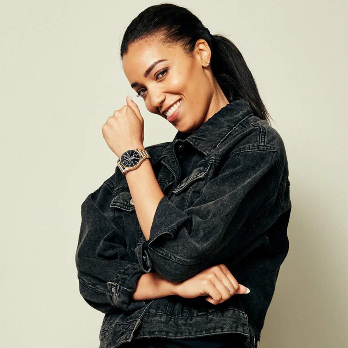 Forside av armbåndsur med svart urskive, gull- og sølvfarget lenke, tydelige indeksmarkører samt dag- og datovisning.