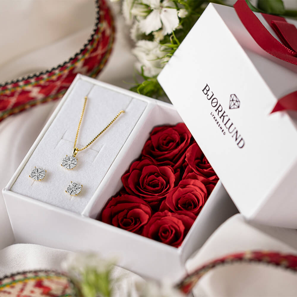 Et par øredobber i gult metall med runde diamantklynger i stjerneformet innfatning, vist mot hvit bakgrunn.