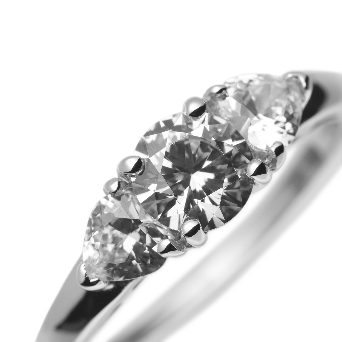 Sølvring med en større rund klar stein i midten og to mindre klare steiner på hver side av fatningen.