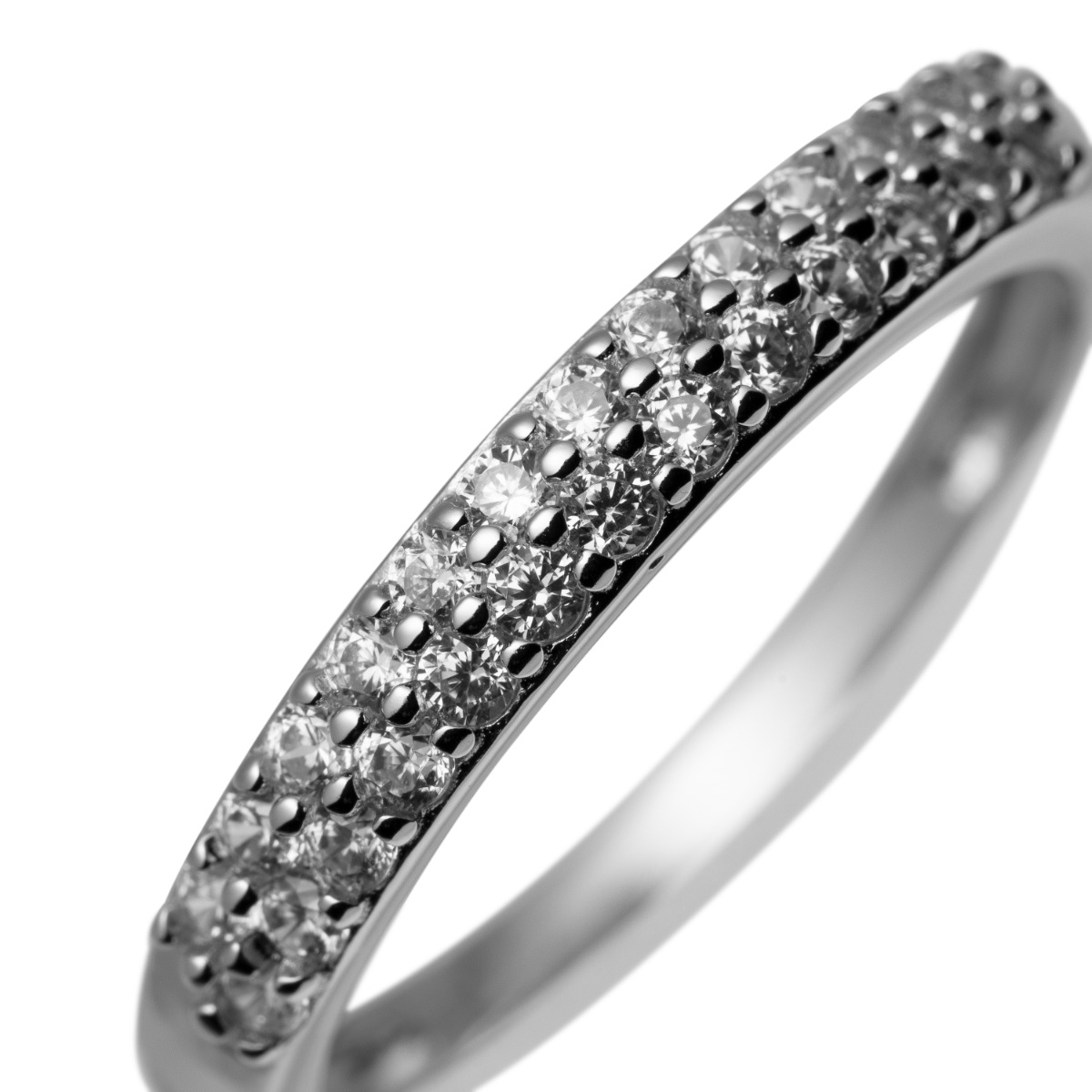 En hånd holder en sølvring med to rader små diamanter i pavé på grå bakgrunn