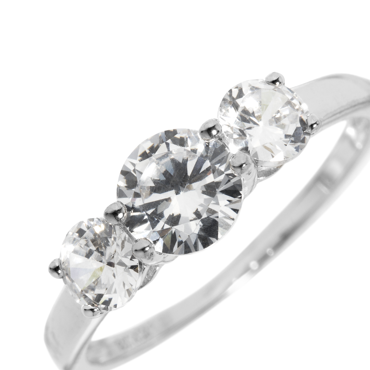 En sølvring med tre runde, klare steiner i rekke, fotografert forfra mot en lys, ensfarget bakgrunn.