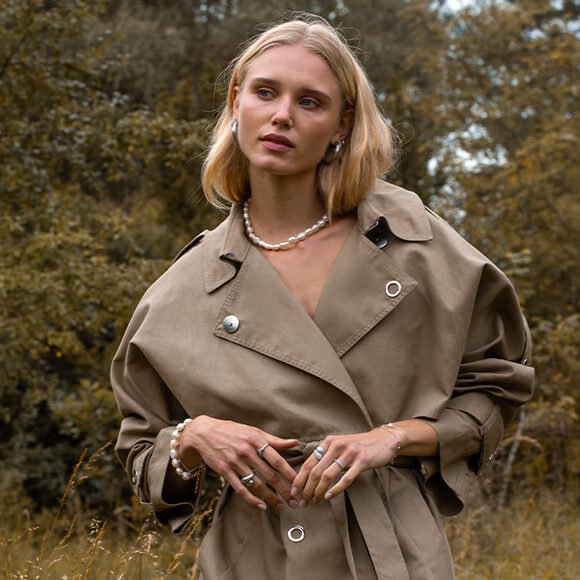 Se Jungle Ivy-kolleksjonen Føttene til en kvinne som sitter på en trapp ute, med havaianas, brettet opp jeans, ringer og ankellenke fra byBiehl Jungle Ivy.