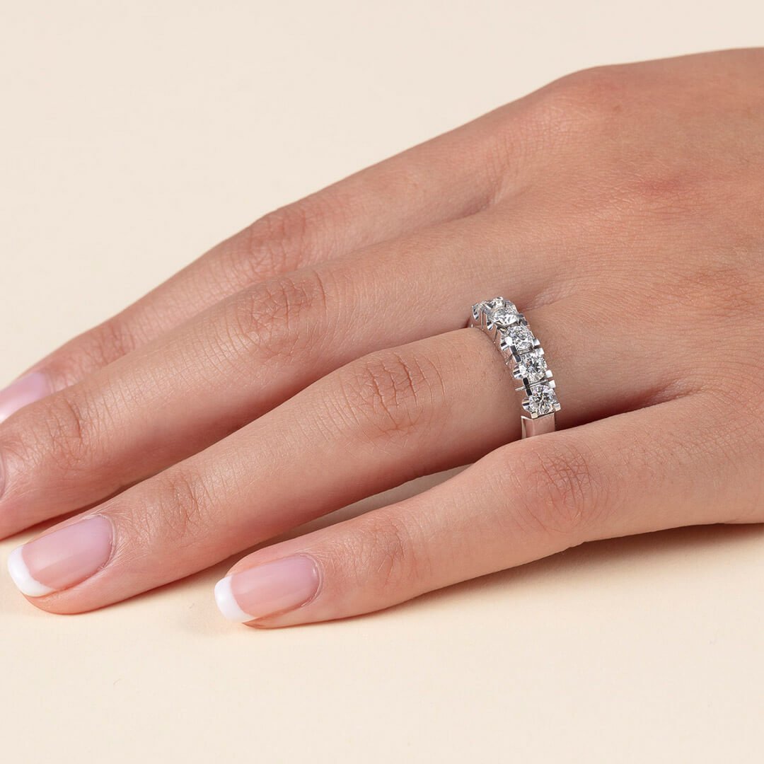 De fire C'er Et nærbilde av en godt vedlikehold kvinnehånd med diamantring. Dette er en ring med fire større diamanter dantert utover ringen.
