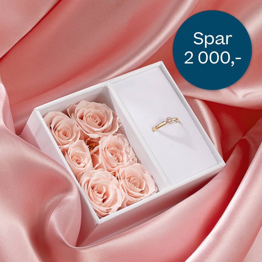 Hvit gaveeske med rosa roser og forlovelsesring i gull på rosa satengbakgrunn. Blå sirkel med tekst 'Spar 2 000,-' viser medlemstilbud.
