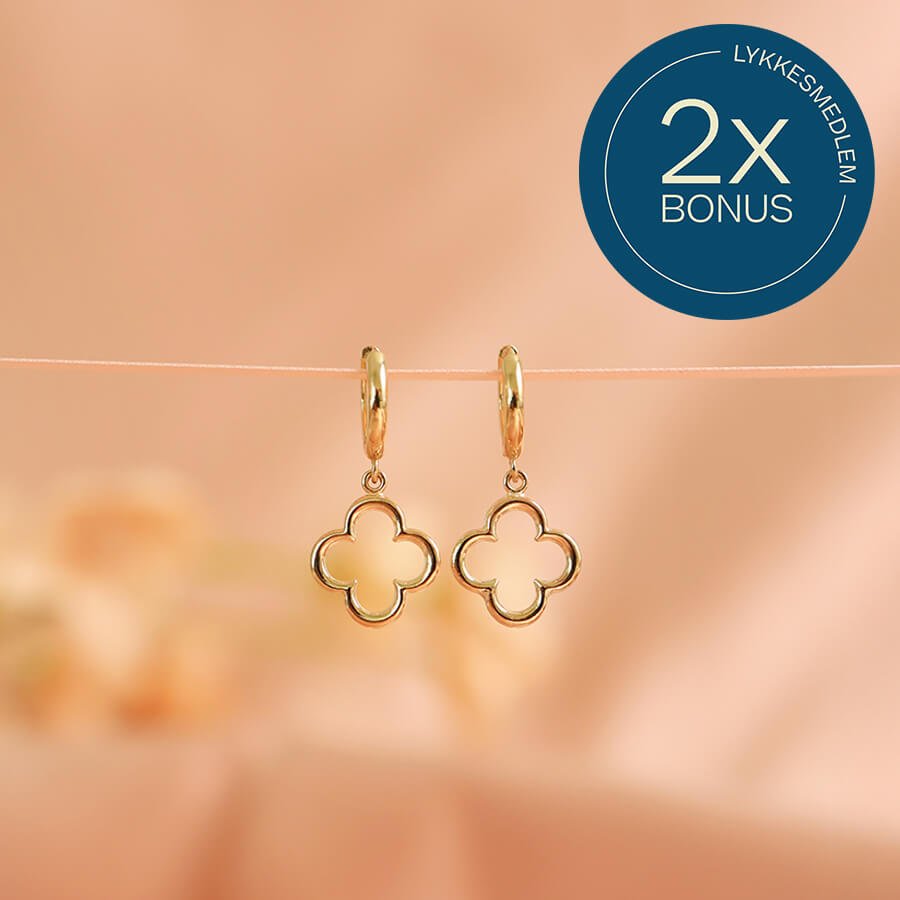 To kløverformede øredobber i gull som henger på en snor, med et blått merke øverst som viser teksten 2x bonus.