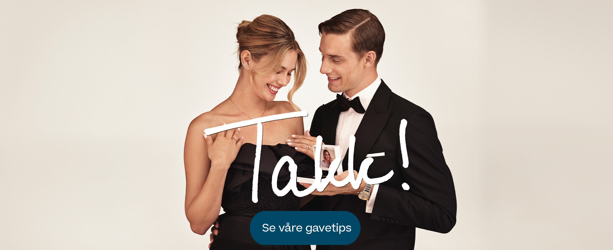 Mann i smoking gir gaveeske med smykke til smilende kvinne i sort kjole, begge ser glade ut, med teksten 'Takk!' nederst