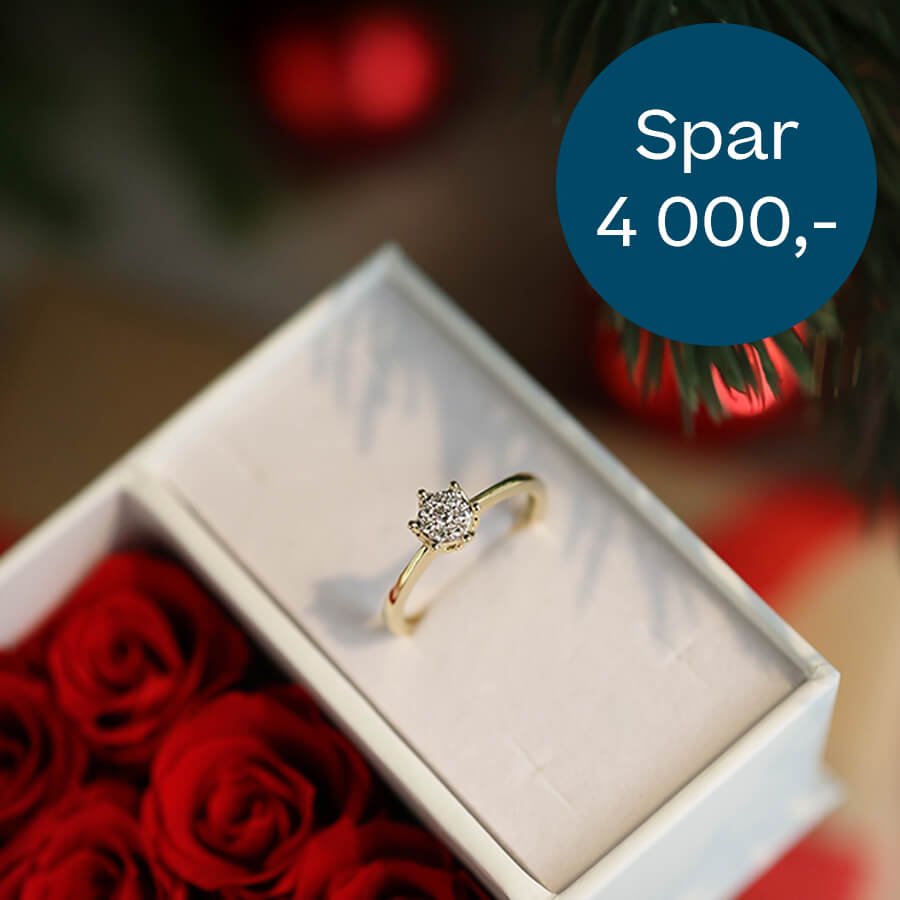 Gullring med diamantbesatt topp i gaveeske pyntet med røde roser, med blå sirkeltekst som viser «Spar 4 000,-».